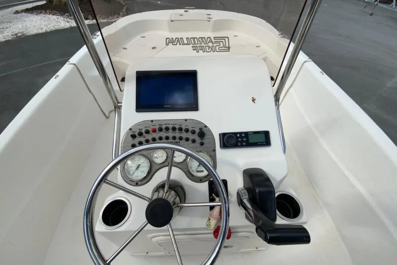 Slide: The Image of 2016 Carolina Skiff 198 DLV boat console with steering wheel and navigation controls. - 17