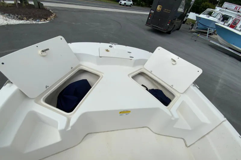 Slide: The Image of 2016 Carolina Skiff 198 DLV boat storage compartments open, showcasing interior space. - 22