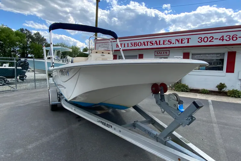 Slide: The Image of 2016 Carolina Skiff 198 DLV boat on trailer at dealership, under a cloudy sky. - 8