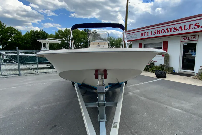 Slide: The Image of 2016 Carolina Skiff 198 DLV boat on trailer at dealership, under cloudy sky. - 9