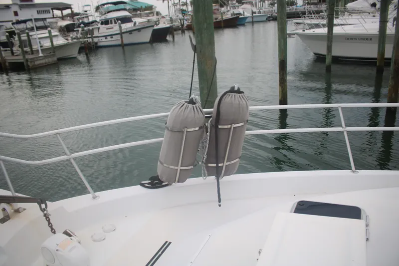 Slide: The Image of 1998 Mainship 47 Motor Yacht docked at marina with fenders on railing. - 13