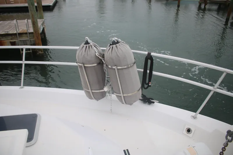 Slide: The Image of 1998 Mainship 47 Motor Yacht with docked fenders on railing. - 14