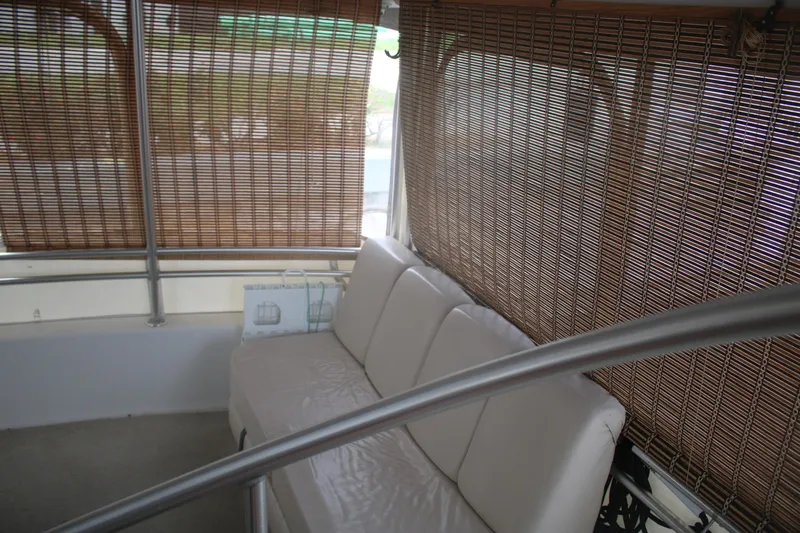 Slide: The Image of Interior of 1998 Mainship 47 Motor Yacht with white seating and bamboo blinds. - 16