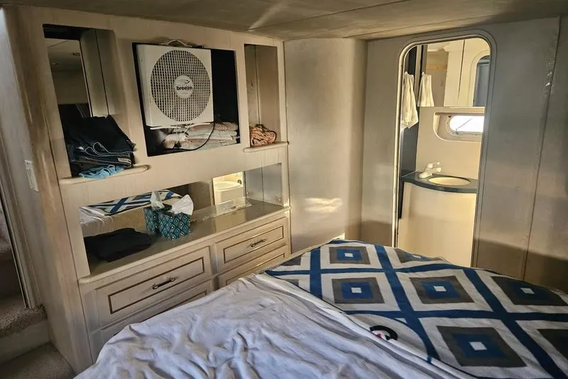 Slide: The Image of Interior of 1998 Mainship 47 Motor Yacht bedroom with bed, storage, and bathroom. - 18