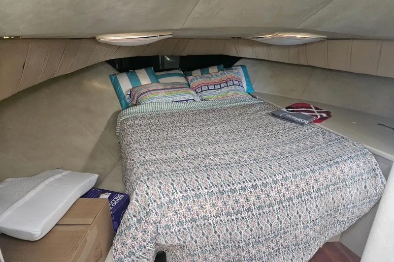 Slide: The Image of Cozy bedroom interior of 1998 Mainship 47 Motor Yacht with patterned bedding and pillows. - 20