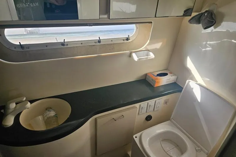 Slide: The Image of Bathroom interior of a 1998 Mainship 47 Motor Yacht, featuring sink and toilet. - 31