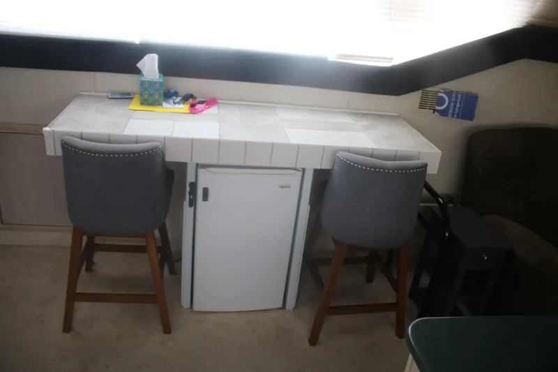 Slide: The Image of Interior of 1998 Mainship 47 Motor Yacht with bar stools and mini fridge. - 33