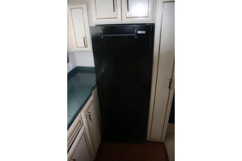 Slide: The Image of Black refrigerator in the kitchen of a 1998 Mainship 47 Motor Yacht. - 36