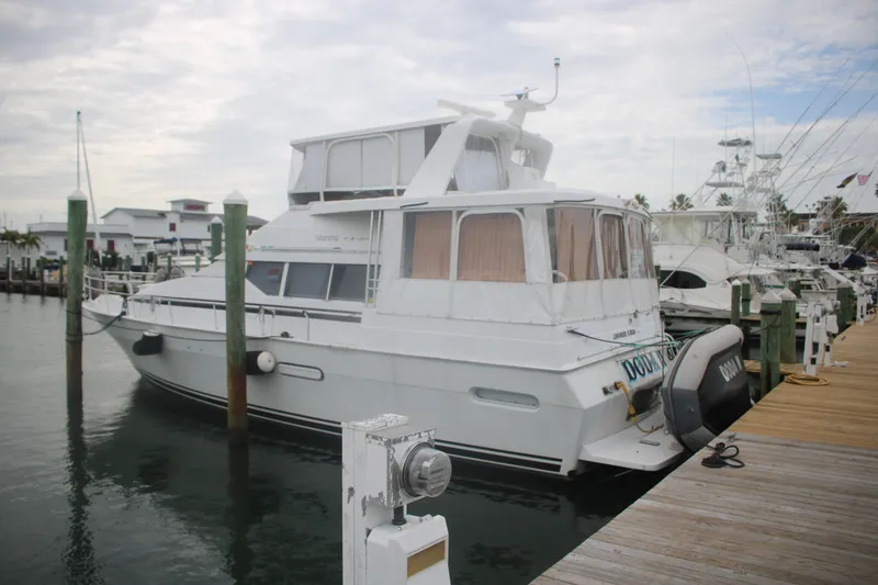 Slide: The Image of 1998 Mainship 47 Motor Yacht docked at marina under cloudy sky. - 4