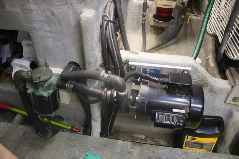Slide: The Image of Engine room of 1998 Mainship 47 Motor Yacht showing mechanical components and hoses. - 46