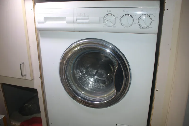 Slide: The Image of Front-loading washing machine inside a 1998 Mainship 47 Motor Yacht laundry area. - 51
