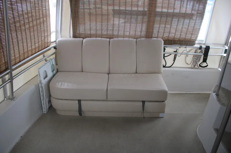Slide: The Image of 1998 Mainship 47 Motor Yacht interior with beige sofa and bamboo blinds. - 52