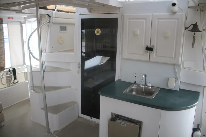 Slide: The Image of Interior of 1998 Mainship 47 Motor Yacht with spiral staircase and compact kitchenette. - 54