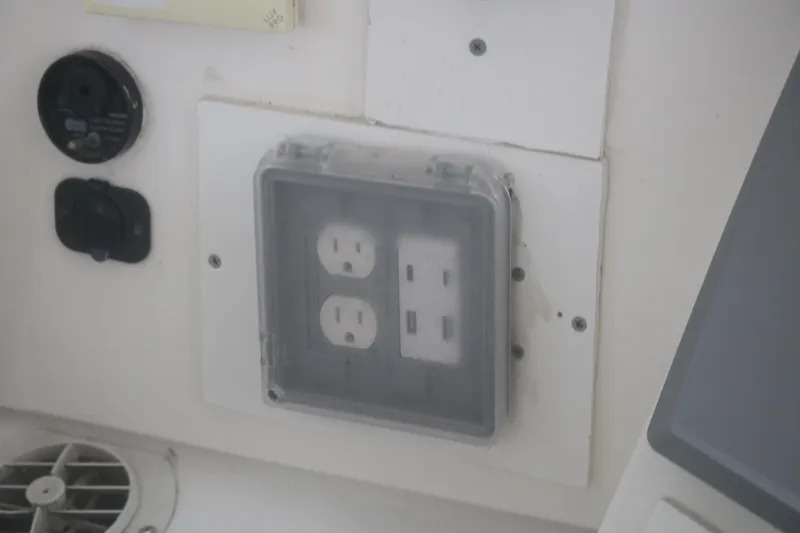 Slide: The Image of Electrical outlet with protective cover on 1998 Mainship 47 Motor Yacht control panel. - 62