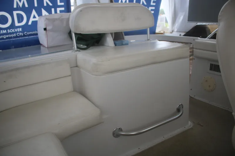 Slide: The Image of 1998 Mainship 47 Motor Yacht interior seating with white cushions and storage compartment. - 67
