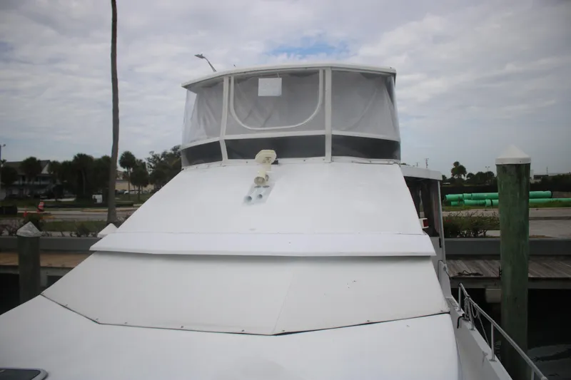 Slide: The Image of 1998 Mainship 47 Motor Yacht docked, featuring a sleek white exterior and enclosed upper deck. - 7