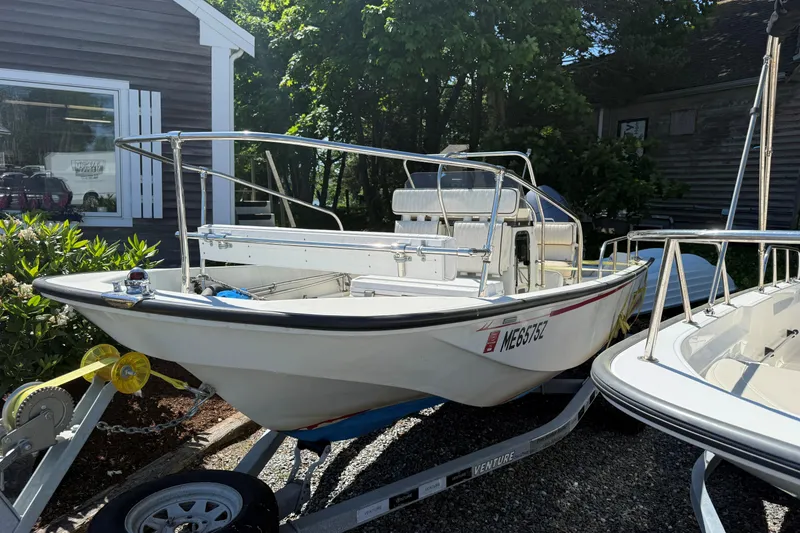 Slide: The Image of 1994 Boston Whaler 17 Montauk boat on trailer, parked outdoors near a building. - 1