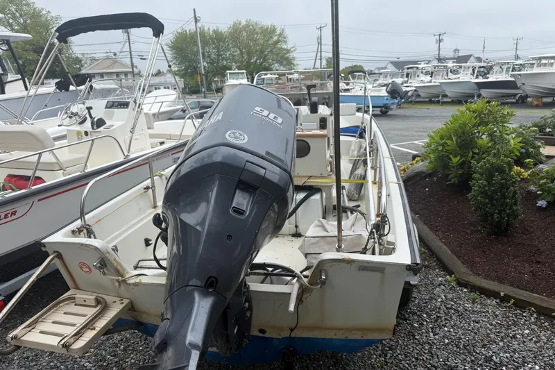 Slide: The Image of 1994 Boston Whaler 17 Montauk boat with Yamaha outboard motor in a marina setting. - 2