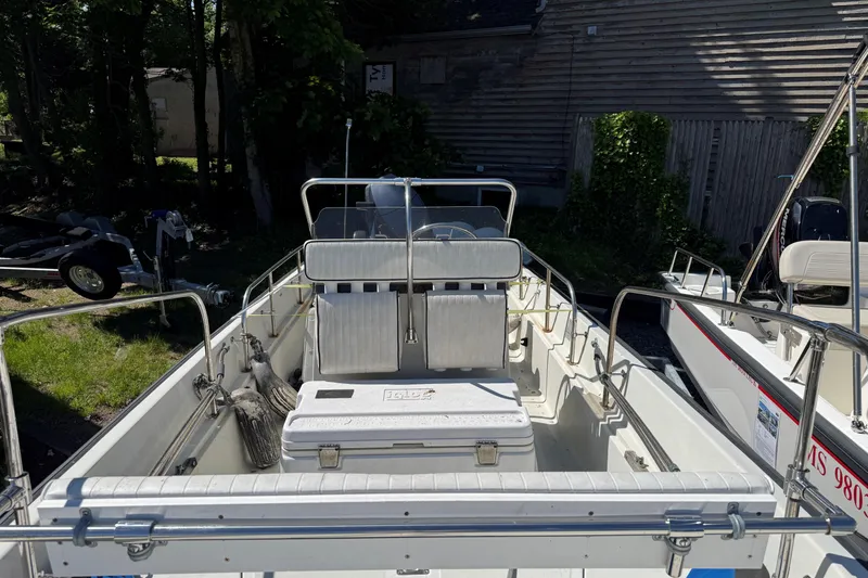 Slide: The Image of 1994 Boston Whaler 17 Montauk boat interior with seating and cooler, parked outdoors. - 4