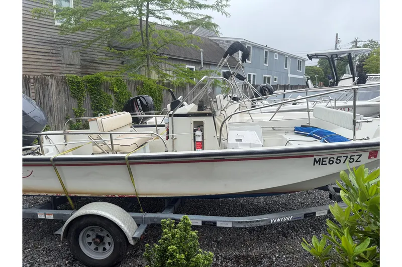 Slide: The Image of 1994 Boston Whaler 17 Montauk boat on trailer, parked outdoors near residential area. - 5