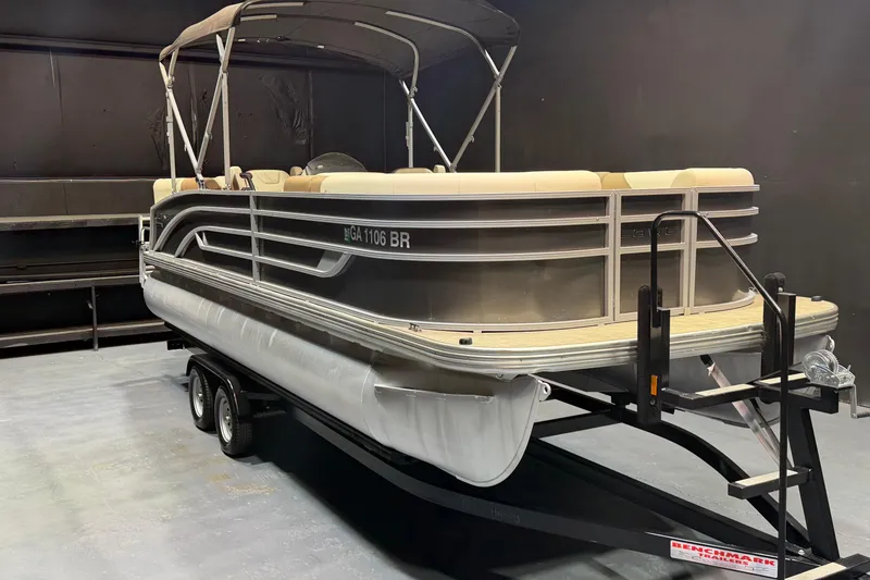 The Image of 2024 Lowe SS 230 pontoon boat on trailer in indoor setting. - 1