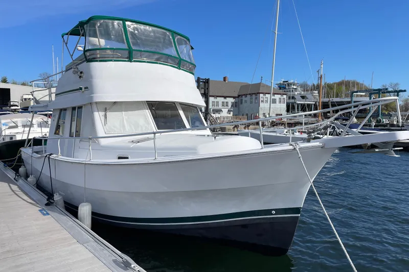 The Image of 2000 Mainship 390 Trawler docked at marina under clear blue sky. - 0