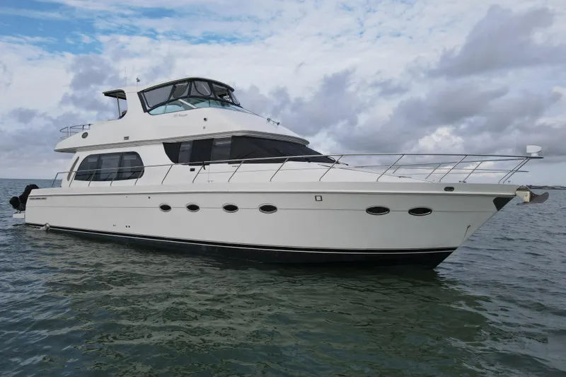 Slide: The Image of 2004 Carver 560 Voyager yacht on calm water under cloudy sky. - 13