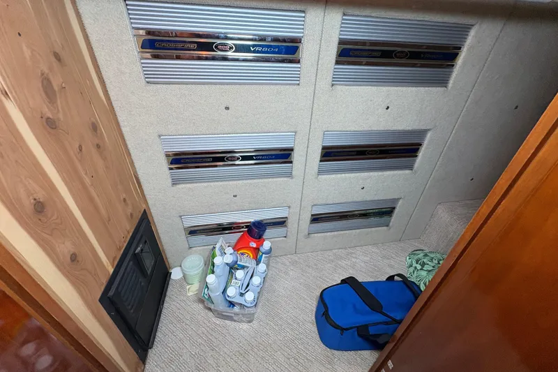 Slide: The Image of Storage area in a 2004 Carver 560 Voyager with cleaning supplies and a blue bag. - 48