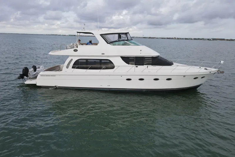 Slide: The Image of 2004 Carver 560 Voyager yacht cruising on calm waters under cloudy skies. - 7