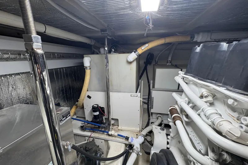 Slide: The Image of Engine room of a 2004 Carver 560 Voyager yacht, showcasing mechanical components and piping. - 89