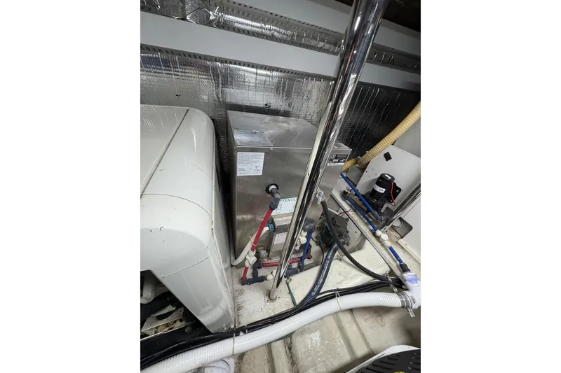 Slide: The Image of Engine room of 2004 Carver 560 Voyager yacht, showcasing mechanical components and piping. - 90