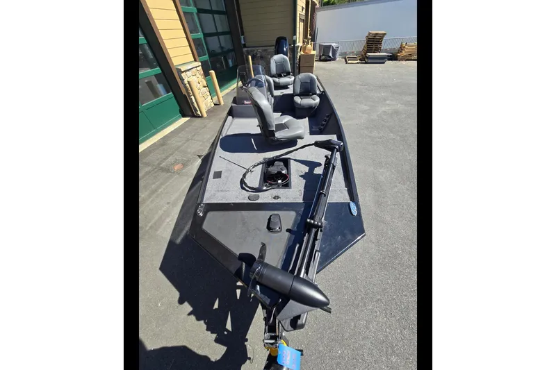Slide: The Image of 2024 Tracker Bass Tracker Classic XL boat with seating and trolling motor, parked outdoors. - 3