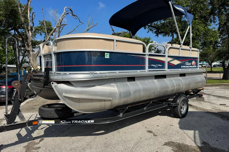 The Image of 2019 Sun Tracker Party Barge 18 DLX pontoon boat on trailer, parked outdoors. - 0