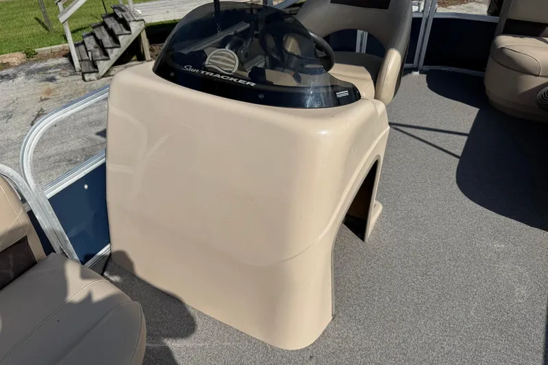 Slide: The Image of 2019 Sun Tracker Party Barge 18 DLX helm with beige console and seating. - 12