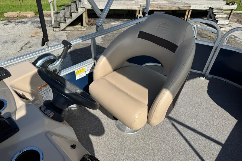 Slide: The Image of 2019 Sun Tracker Party Barge 18 DLX helm with beige captain's chair and steering wheel. - 14