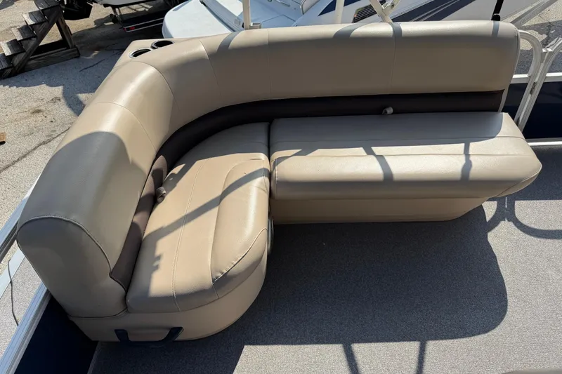 Slide: The Image of 2019 Sun Tracker Party Barge 18 DLX beige seating area with cup holder. - 15
