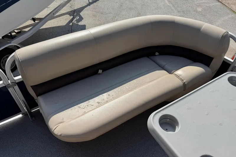 Slide: The Image of 2019 Sun Tracker Party Barge 18 DLX seating area with beige upholstery and table. - 4