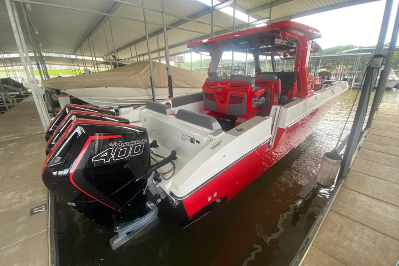 Slide: The Image of 2025 Fountain 38 SCX boat with triple Racing 400 engines, docked in a covered marina. - 11