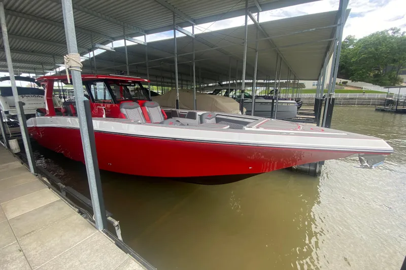 Slide: The Image of Red 2025 Fountain 38 SCX boat docked under a covered marina. - 12