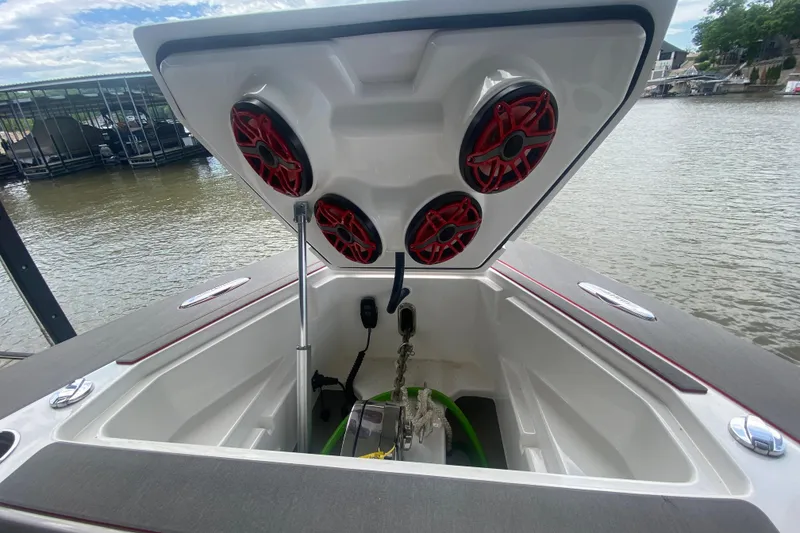 Slide: The Image of 2025 Fountain 38 SCX boat storage compartment with red speakers, docked by the water. - 23