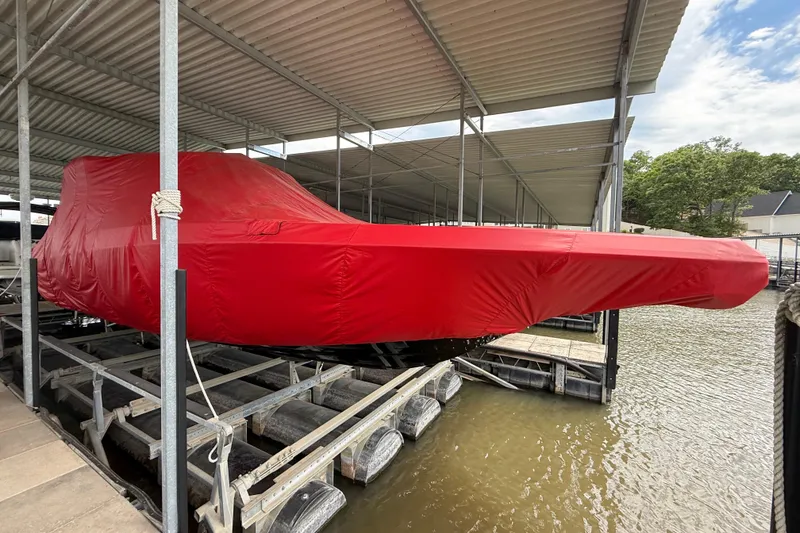 Slide: The Image of 2025 Fountain 38 SCX boat covered in red tarp, docked at marina. - 34
