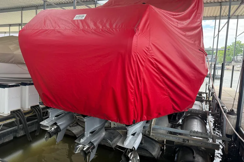 Slide: The Image of Covered 2025 Fountain 38 SCX boat with red tarp, docked with visible outboard motors. - 36