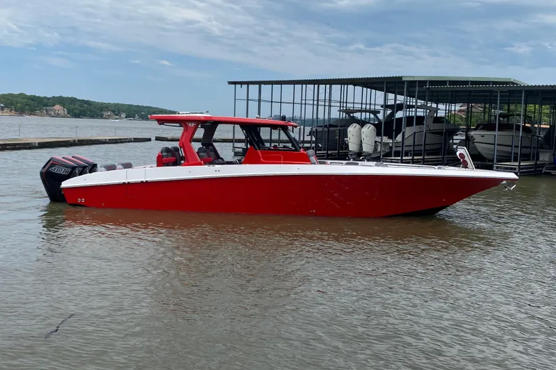 Slide: The Image of 2025 Fountain 38 SCX boat in vibrant red, docked on a calm lake. - 8