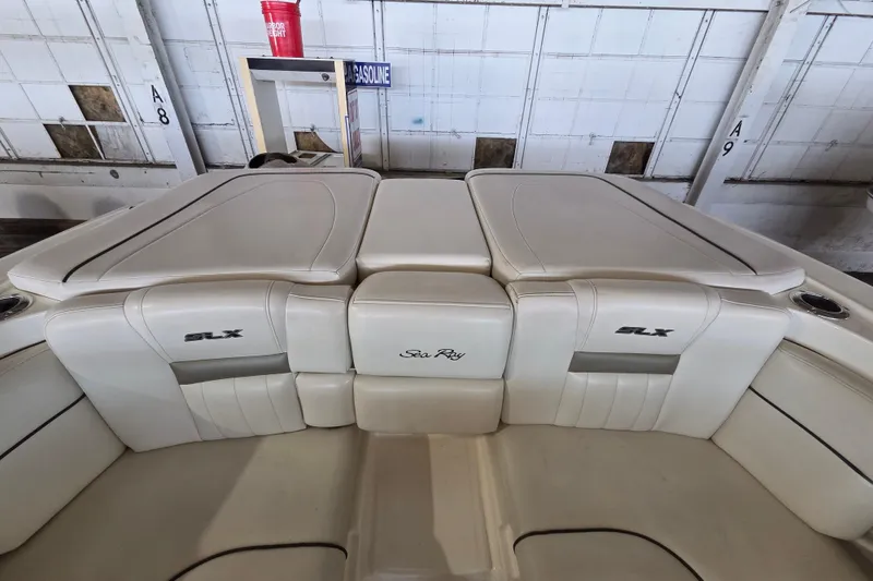 Slide: The Image of 2005 Sea Ray 270 SLX boat interior with white leather seating in a garage. - 19