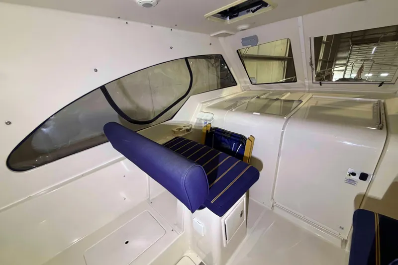 Slide: The Image of 2005 Mainship Pilot 34 interior with blue seating and large windows. - 11