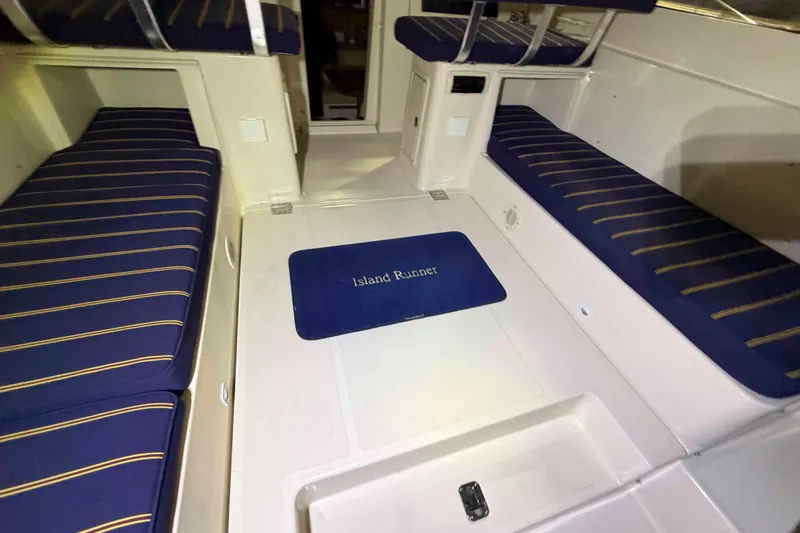 Slide: The Image of 2005 Mainship Pilot 34 interior with blue-striped seating and "Island Runner" mat. - 15