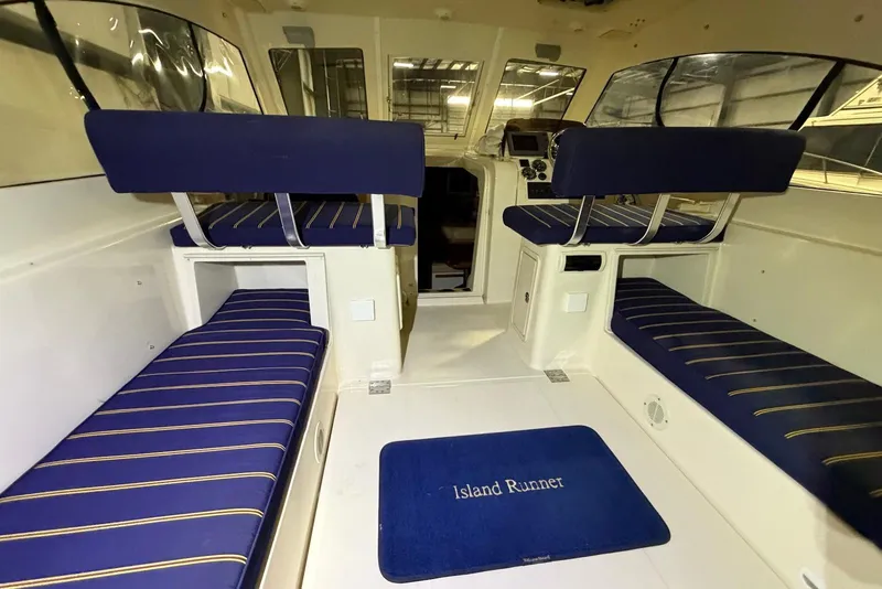 Slide: The Image of Interior of 2005 Mainship Pilot 34 boat with blue seating and "Island Runner" mat. - 16