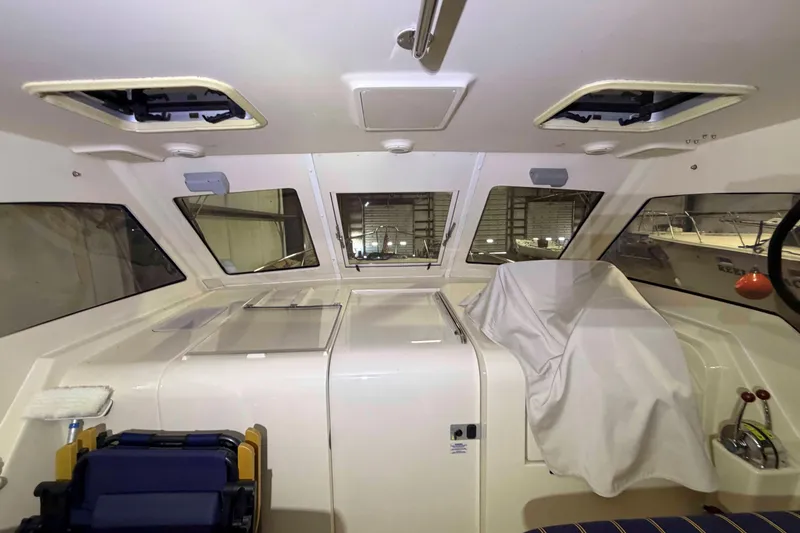 Slide: The Image of Interior view of a 2005 Mainship Pilot 34 boat cabin with covered controls. - 17