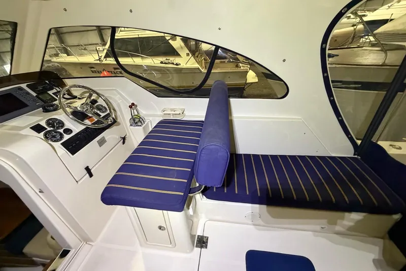 Slide: The Image of 2005 Mainship Pilot 34 helm with blue-striped seating and navigational controls. - 18