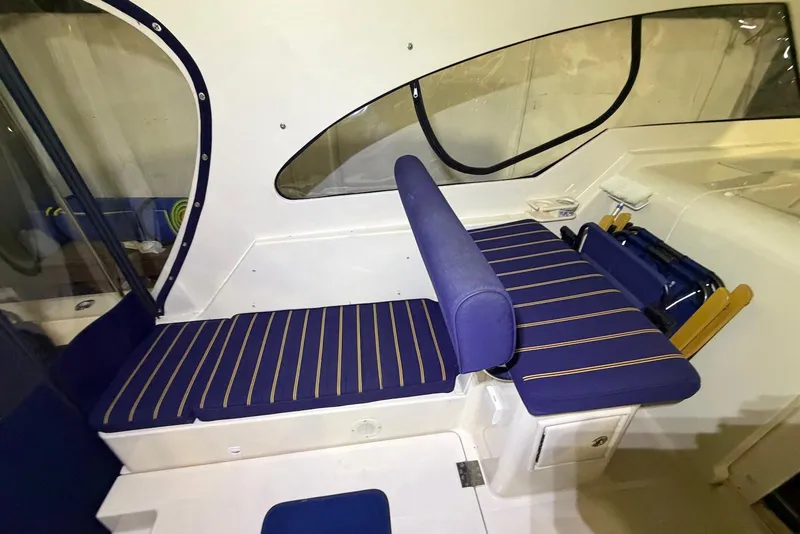 Slide: The Image of 2005 Mainship Pilot 34 interior with blue striped seating and window view. - 19